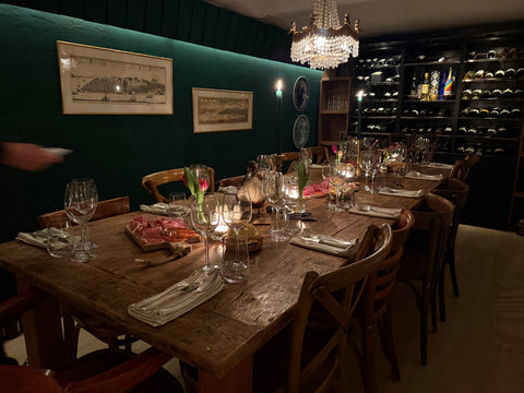 Gedekte wijnavondtafel met charcuterie, kaarsen en kroonluchter in de wijnkelder van In Den Hendrick